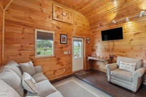 a living room with wooden walls and a flat screen tv at Higden Hideaway with Fire Pit Near Greers Ferry Lake in Fairfield Bay