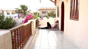a woman sitting on the porch of a house at Nook in Dahab