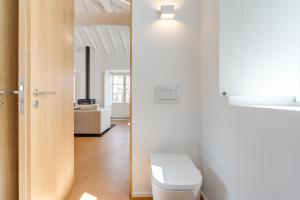 a white bathroom with a toilet and a room at Miragaia Apartments by DA'HOME in Porto