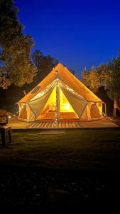 Une grande tente est éclairée la nuit. dans l'établissement ELIES TINY GLAMPING, à Ayvalık