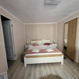een slaapkamer met een wit bed en een spiegel bij Casa centru vechi sibiu in Sibiu