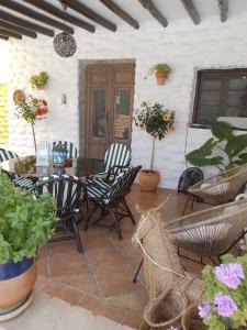 a patio with a table and chairs and potted plants at Casas Amaro in Órgiva