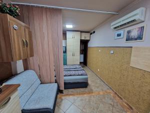 Una pequeña habitación con una cama y un sofá. en Splendor apartman, en Debrecen