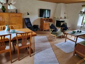 uma sala de estar com uma mesa e cadeiras e uma televisão em Slättö 17 Lammhult em Lammhult