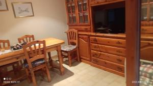 Estadilla的住宿－casaelrubioturismorural，厨房配有木桌、椅子和电视。