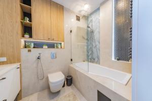 a bathroom with a toilet and a sink and a shower at Łódź Spacious Apartments by Rentujemy in Łódź