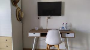 een bureau met een stoel en een televisie aan de muur bij B&B Il Carlino in Villaggio Azzurro
