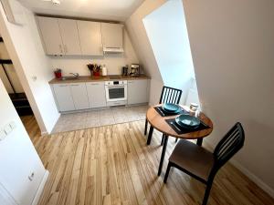cocina y comedor con mesa y sillas en Jacob’s Barracks apartment in Old Town en Riga