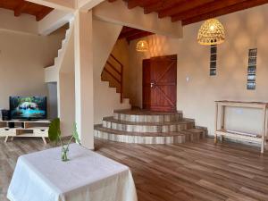 a living room with a table and a tv and stairs at Avista al Rio in Puerto Iguazú