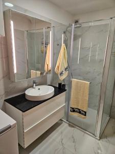 a bathroom with a sink and a shower with a mirror at Magic Eden Rijeka in Rijeka +16 photos