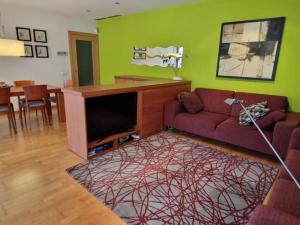 a living room with a couch and a green wall at Homing Sabadell 73 in Sabadell