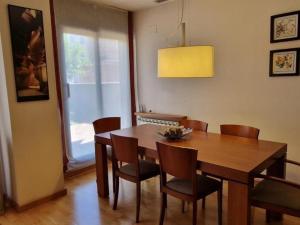 comedor con mesa de madera y sillas en Homing Sabadell 73, en Sabadell