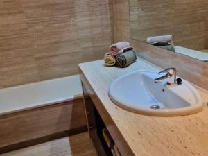 een badkamer met een wastafel, een spiegel en een bad bij Homing Sabadell 73 in Sabadell