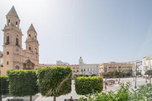 カディスにあるEl Espíritu de Cádizの大聖堂や木々、建物のある市の広場