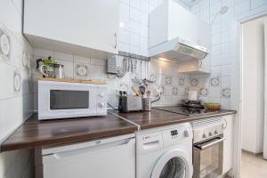 a kitchen with a microwave and a washer and dryer at El Espíritu de Cádiz in Cádiz