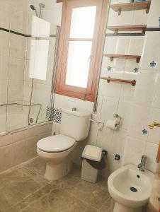 a bathroom with a toilet and a shower and a sink at ATICO ESTUPENDO in Calabardina