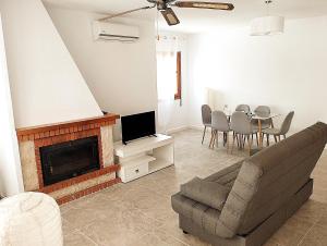 sala de estar con sofá, mesa y TV en ATICO ESTUPENDO, en Calabardina