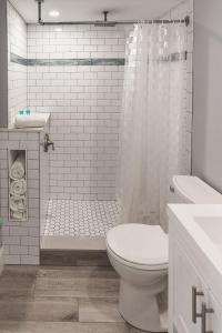 biała łazienka z toaletą i prysznicem w obiekcie Sea Horse Motel w mieście Brant Beach
