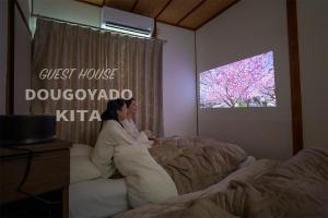 松山市にあるGUEST HOUSE DOUGOYADO KITAの夫婦が寝室のベッドに寝ている