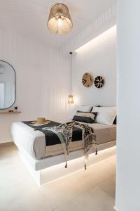 - une chambre blanche avec un grand lit et un miroir dans l'établissement Philisios Home 2, à Naxos Chora