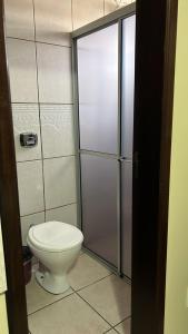 a bathroom with a toilet and a shower stall at Hotel Germânia Nova Veneza in Nova Veneza