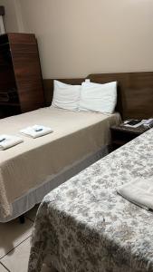 2 camas en una habitación de hotel con 2 camas en Hotel Germânia Nova Veneza, en Nova Veneza