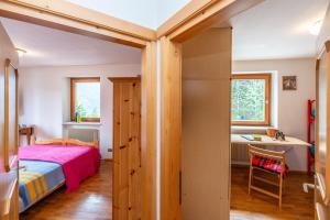 1 dormitorio con cama y escritorio en Sport & natura in Trentino! en Vigo di Fassa