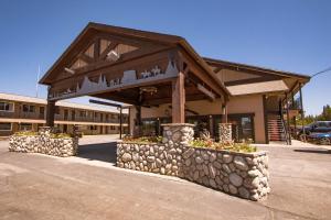 a building with a stone wall in a parking lot at Brandin' Iron Inn in West Yellowstone