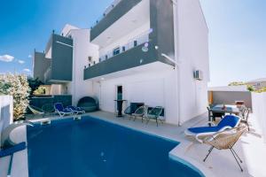 basen z krzesłami i dom w obiekcie VIP Deluxe Villa JASMINA w Novalji