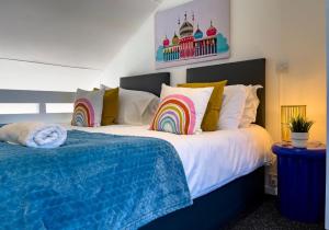 Schlafzimmer mit einem Bett und Regenbogenkopfkissen in der Unterkunft On the Water 4 with Free Parking By My Getaways in Brighton & Hove