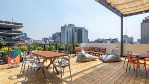 a wooden deck with a table and chairs on a roof at Triver Coliving in Mexico City