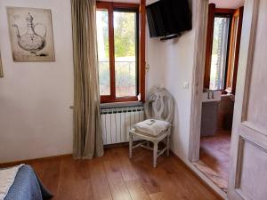 1 dormitorio con silla y TV. en DAGO Farmhouse en Siena