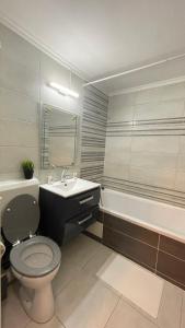 La salle de bains est pourvue de toilettes, d'un lavabo et d'une baignoire. dans l'établissement ABarbici Apartments, à Bucarest