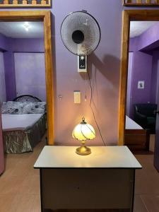 a lamp on a table in a room with a fan at Budget Friendly Apartment 2rms in Baguio