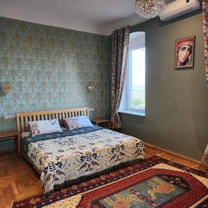 1 dormitorio con cama, ventana y alfombra en Villa Kursa en Sighnaghi