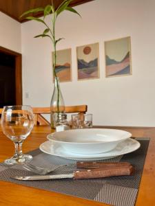 uma mesa com um prato branco e um vaso sobre ela em Casa Jabuticaba a 5 min dos Thermas e Hot Beach em Olímpia