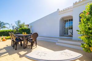 um pátio com uma mesa e cadeiras e um edifício em Villa Menorca by Algarve Vacation em Armação de Pêra