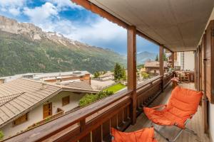 a balcony with chairs and a view of mountains at Sport & natura in Trentino! in Vigo di Fassa