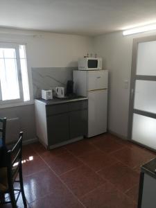 W kuchni znajduje się biała lodówka i kuchenka mikrofalowa. w obiekcie Katia w mieście Roquebrune-sur Argens