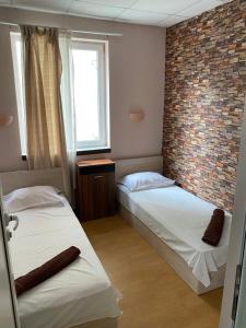 two beds in a room with a brick wall at Romance in Pomorie