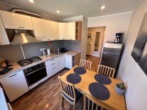 a kitchen with a wooden table and a dining room at Modern city center apartment in Sigulda