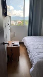 1 dormitorio con 1 cama y 1 mesa con lámpara en HABITACION DOBLE con baño compartido en apartamento compartido, en Bucaramanga