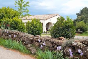 a stone retaining wall in front of a house at Le Chausse à Brès Chambre d'hôtes 2 in Payzac