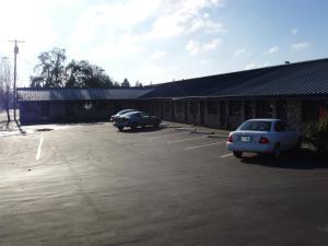 twee auto's geparkeerd op een parkeerplaats voor een gebouw bij Towne and Country Motel in Newberg