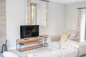 a living room with a couch and a tv at No 1 The Coach House in Carnforth