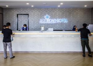 people standing at a reception counter at a suneland hotel at Sri Indar Hotel & Suites in Parit Buntar