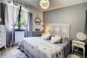 a bedroom with a bed with purple walls and a chandelier at O jardin des Sens -Séjour Bien-être & détente &Jacuzzi in Béziers +39 photos