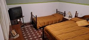 um quarto de hotel com duas camas e uma televisão em Casa Linda em Salta