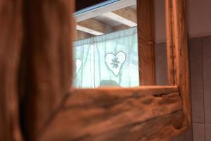 una ventana con un corazón dibujado en una cortina en Chalet Navauce en Raveo