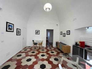 Habitación blanca grande con mesa y cocina en Palazzo Lamantea Boutique Rooms, en Bisceglie